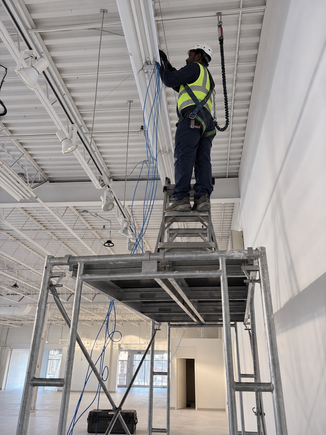 Installer using safety equipment on commercial scaffolding